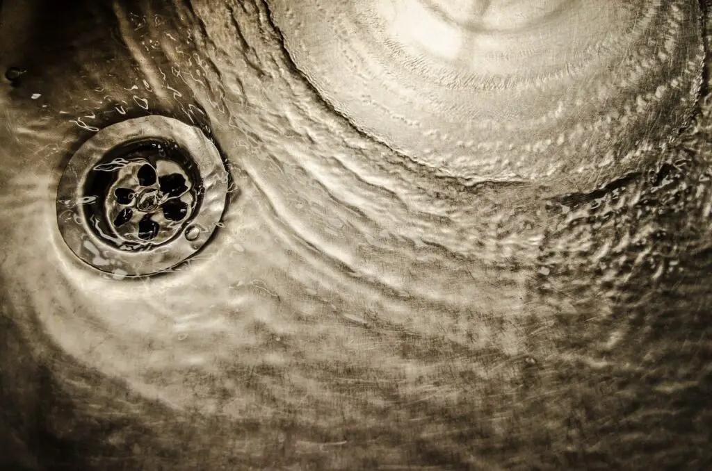 water cricling down the drain of a sink