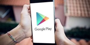 hand holding a smartphone displaying google play app