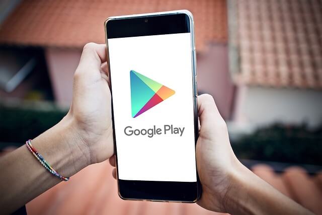 hand holding a smartphone displaying google play app