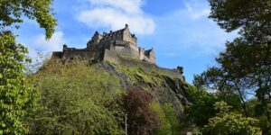 low wide shot of Edinburgh Castle surrounded by trees during the day