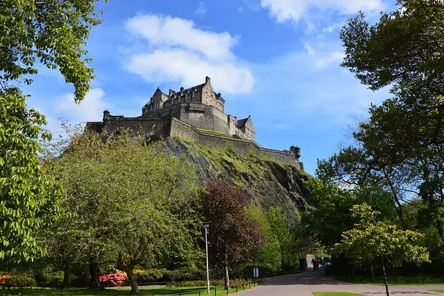 low wide shot of Edinburgh Castle surrounded by trees during the day