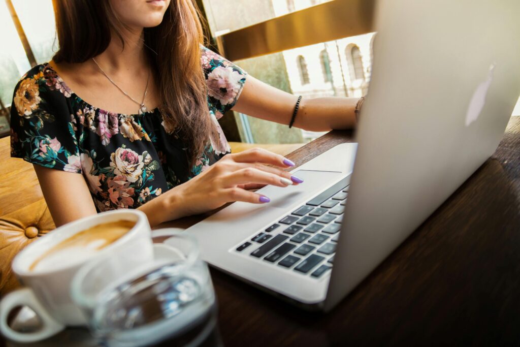 an employee working remotely on a laptop with a cup of coffee